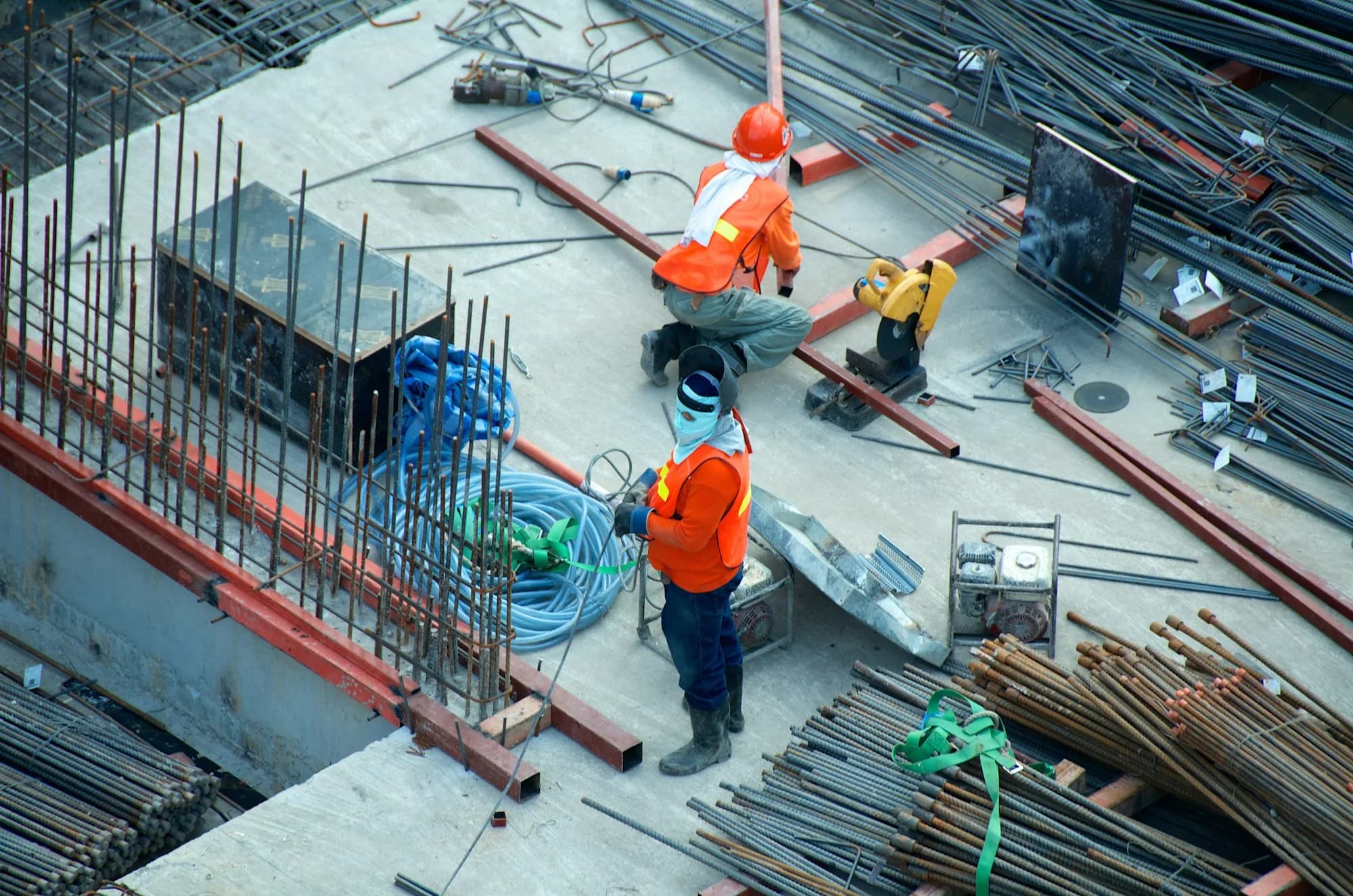 Construction workers preparing steel reinforcement on a building site